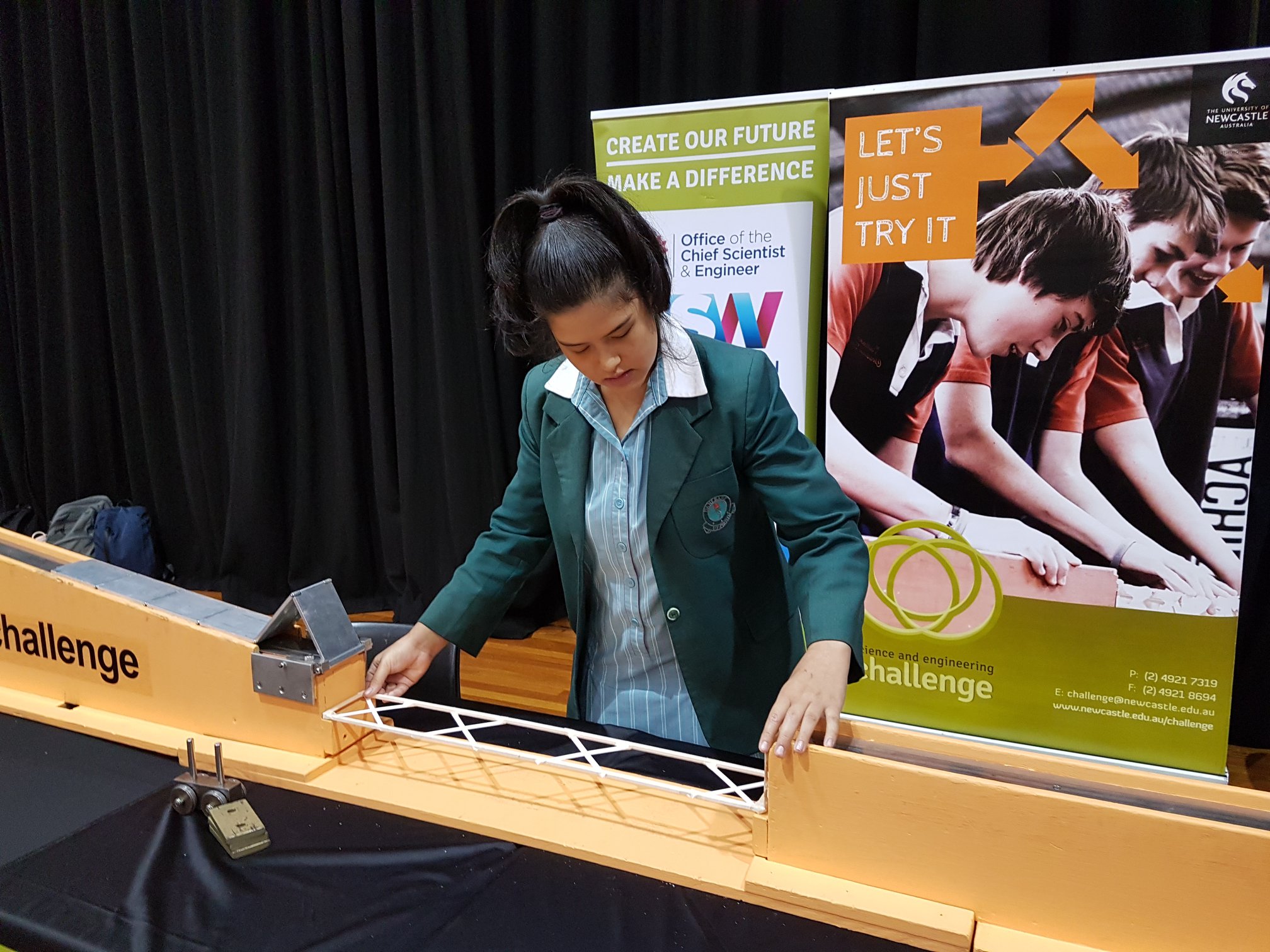 A student builds a balsa wood bridge at the 2019 SEC.