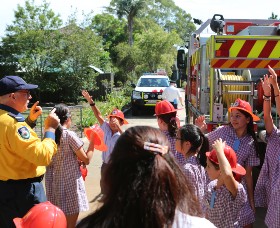 School children in front of a fire engine with an RFS representative addressing them.